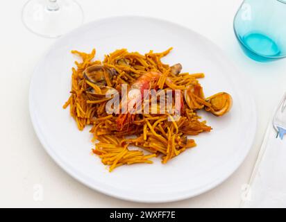 Plat traditionnel espagnol de fruits de mer fideua avec sauce aïoli dans un restaurant Banque D'Images