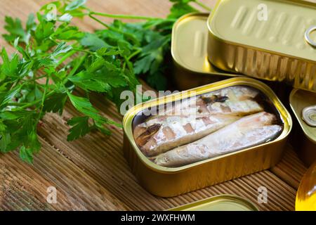 Fruits de mer en conserve, maquereau sans tête conservé dans l'huile sur une table en bois Banque D'Images