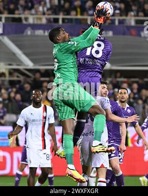 Florence, Italie. 30 mars 2024. Le M Bala Nzola de Fiorentina affronte Mike Maignan d'AC Milan lors d'un match de football en Serie A à Florence, en Italie, le 30 mars 2024. Crédit : Augusto Casasoli/Xinhua/Alamy Live News Banque D'Images