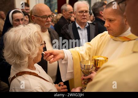 Varsovie, Pologne. 30 mars 2024. Les gens prennent le pain de communion ou l'hôte avant la procession de Pâques à Varsovie, Pologne, le 30 mars 2024. Pâques est l'une des fêtes les plus importantes dans le pays majoritairement catholique et est célébrée par les familles conservatrices et les familles modernes. (Photo de Jaap Arriens/Sipa USA) crédit : Sipa USA/Alamy Live News Banque D'Images