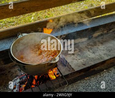 Cuisson des aliments dans un chaudron sur feu ouvert Banque D'Images