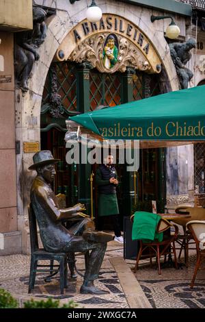 Statue d'un homme assis à une table devant une brasileira do chiado. Lisbonne, Portugal. 2 février 2024. Banque D'Images