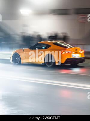 SYMBOLE - 29 mars 2024, Rhénanie-Palatinat, Nürburg : une voiture roule sur une route dans le noir sur ce que l'on appelle le «vendredi de la voiture» au Nürburgring. Car Friday' est l'ouverture de la saison pour les fans de voitures. Photo : Silas Stein/dpa Banque D'Images