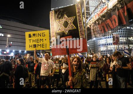 Tel Aviv, Israël. 30 mars 2024. Des manifestants israéliens brandissent une pancarte avec l'étoile de David réalisée à partir des photos de l'otage israélien peintes en rouge. Des dizaines de milliers de personnes ont manifesté avec les familles d’otages contre le premier ministre Benjamin Netanyahu à tel Aviv, exigeant un accord immédiat sur les otages. Des affrontements avec la police israélienne ont eu lieu après que des manifestants eurent déclenché quelques feux de joie et bloqué la route d'Ayalon dispersée par des canons à eau de la police. Crédit : SOPA images Limited/Alamy Live News Banque D'Images