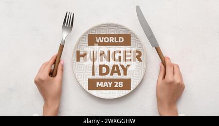 Bannière pour la Journée mondiale de la faim avec femme à table avec assiette vide Banque D'Images