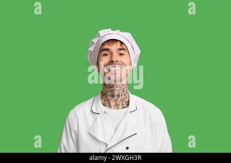 Jeune chef souriant sur fond vert Banque D'Images