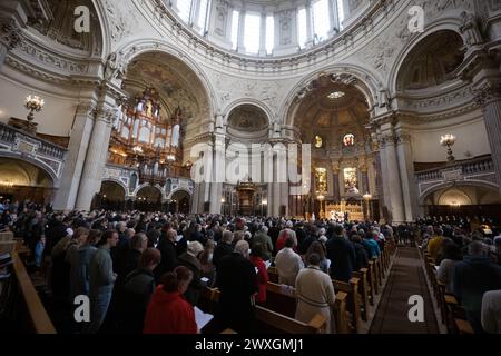 Berlin, Allemagne. 31 mars 2024. Les visiteurs se tiennent debout pendant le service du dimanche de Pâques dans la cathédrale de Berlin. Crédit : Sebastian Christoph Gollnow/dpa/Alamy Live News Banque D'Images