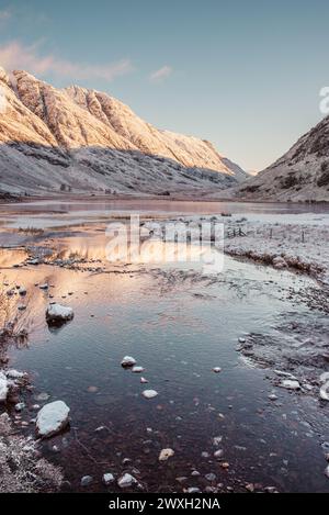 Les montagnes enneigées de Glencoe se reflètent dans les eaux du Loch Achtriochtan dans les Highlands écossais Banque D'Images