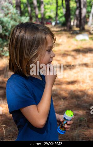 Portrait d'enfant de profil dans la nature regardant curieux Banque D'Images