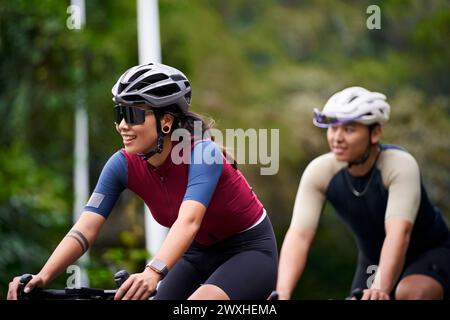 jeunes cyclistes de couple asiatique faisant du vélo sur la route rurale Banque D'Images