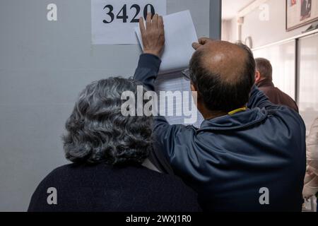 Ankara, Turquie. 31 mars 2024. Les électeurs recherchent leurs noms sur la liste affichée à la porte d'un bureau de vote lors des élections locales turques de 2024. Les bureaux de vote turcs pour élire leurs administrateurs locaux qui serviront pendant 5 ans. Plus de 61 millions d'électeurs ont voté, dans environ 208 000 urnes. Alors que le vote commence à 08,00 heures du matin à Ankara, des milliers de citoyens se rendent aux urnes tôt le matin pour voter. Crédit : SOPA images Limited/Alamy Live News Banque D'Images