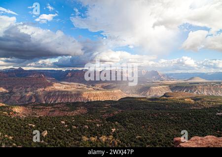 Une vue panoramique sur les montagnes lointaines du parc national de Zion et la vallée environnante avec des nuages bas et de la pluie contre un ciel bleu. Banque D'Images