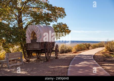 Un vieux wagon couvert en bois exposé sur le site historique de Pipe Springs National Monument à côté d'une passerelle et une vue sur le désert ouvert dans le di Banque D'Images