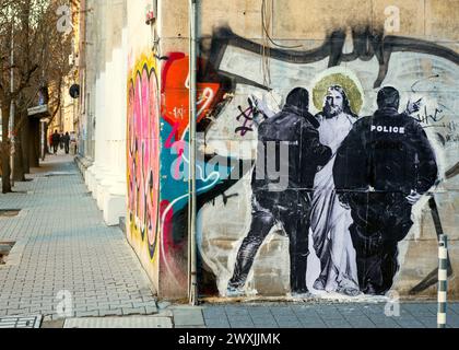 Jésus-Christ arrêté par des agents de police Wheatpaste Street poster art graffiti mural à Sofia Bulgarie, Eueopw oriental, Balkans, UE Banque D'Images