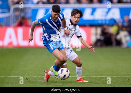 Takefusa Kubo de Real Sociedad concourt pour le ballon avec Javi Lopez de Deportivo Alaves lors du match LaLiga EA Sports entre Deportivo Alaves et Real Sociedad à Mendizorrotza le 31 mars 2024, à Vitoria, en Espagne. Banque D'Images