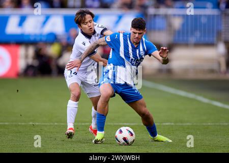 Takefusa Kubo de Real Sociedad concourt pour le ballon avec Javi Lopez de Deportivo Alaves lors du match LaLiga EA Sports entre Deportivo Alaves et Real Sociedad à Mendizorrotza le 31 mars 2024, à Vitoria, en Espagne. Banque D'Images