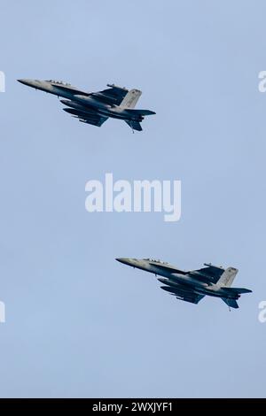 MER DE CHINE MÉRIDIONALE (30 mars 2024) deux EA-18G Growlers, rattachés aux « tours » de l’Electronic Attack Squadron (VAQ) 137, survolent le porte-avions de classe Nimitz USS Theodore Roosevelt (CVN 71), le 30 mars 2024. Theodore Roosevelt, navire amiral du Carrier Strike Group Nine, mène des opérations de routine dans la zone d'opérations de la 7e flotte américaine. La 7e flotte américaine est la plus grande flotte numérotée déployée vers l’avant de l’US Navy. Elle interagit et opère régulièrement avec des alliés et des partenaires pour préserver une région indo-pacifique libre et ouverte. (Photo de l'US Navy par le spécialiste des communications de masse 3rd Cl Banque D'Images