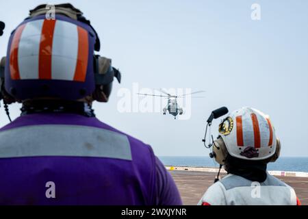 Les marins affectés au navire de transport amphibie de classe San Antonio USS Somerset (LPD 25) surveillent un Sea King UH-3H de la marine de la République de l'Inde à l'approche du pont d'envol, alors qu'il est en route dans la baie du Bengale, Mar. 28, 2024, lors de l'exercice Tiger TRIUMPH 2024. Tiger TRIUMPH est un exercice amphibie de trois services entre les États-Unis et l'Inde axé sur l'aide humanitaire et la préparation et l'interopérabilité des secours en cas de catastrophe. (Photo de l'US Navy par Evan Diaz, spécialiste des communications de masse, 2e classe) Banque D'Images