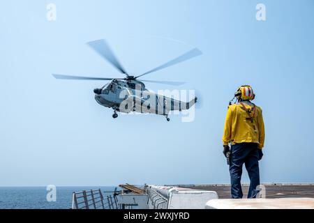 Avion Boatswain’s Mate (Handling) 1re classe Reyvin Olaes, originaire de Cavite, Philippines, surveille un Sea King de la marine de la République de l’Inde UH-3H sur le pont d’envol du navire amphibie de transport USS Somerset (LPD 25) alors qu’il se dirigeait dans la baie du Bengale, Marc 28, 2024, pendant l'exercice Tiger TRIUMPH 2024. Tiger TRIUMPH est un exercice amphibie de trois services entre les États-Unis et l'Inde axé sur l'aide humanitaire et la préparation et l'interopérabilité des secours en cas de catastrophe. (Photo de l'US Navy par Evan Diaz, spécialiste des communications de masse, 2e classe) Banque D'Images