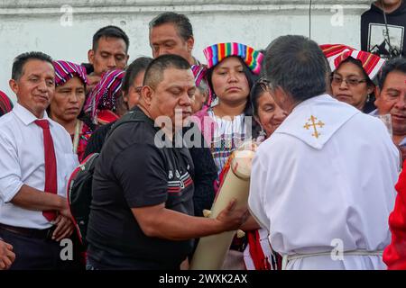 Chichicastenango, Guatemala. 30 mars 2024. Un prêtre catholique allume des bougies pendant une cérémonie chrétienne et maya avant une veillée aux chandelles pour Jésus le samedi Saint au Cementerio de Chichicastenango, le 30 mars 2024 à Chichicastenango, Guatemala. L’Église catholique et les croyances mayas se sont mélangées il y a longtemps dans les régions indigènes du Guatemala dans un processus appelé syncrétisme. Crédit : Richard Ellis/Richard Ellis/Alamy Live News Banque D'Images