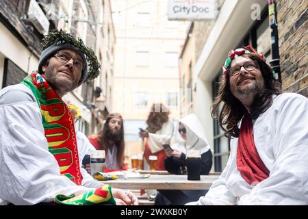 Londres, Royaume-Uni. 31 mars 2024. Les participants habillés comme Jésus s'assoient dans un pub lors de l'événement annuel Fancy Dress pub crawl. Un groupe de passionnés de pub crawl habillés en Jésus et d'autres personnages bibliques participent au Christathon annuel, un pub crawl dans le centre de Londres le dimanche de Pâques. C'est le 17e anniversaire de la tournée annuelle des pubs de fantaisie sur le thème de la Crucifixion. Crédit : SOPA images Limited/Alamy Live News Banque D'Images