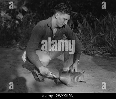 Département du canal de Panama. Manœuvres du département. "Réservoir blindé en acier tropical." Soldat sur le terrain avec un armadillo, qui était l'animal de compagnie de la tenue. (Notez la peau ressemblant à une armure de l'armadillo) CA. 1934 Banque D'Images