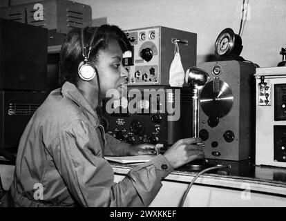 Cette photographie représente une jeune femme alors qu'elle teste les réparations faites à une radio lors d'un atelier de l'Administration nationale de la jeunesse CA. 1939-1943 Banque D'Images