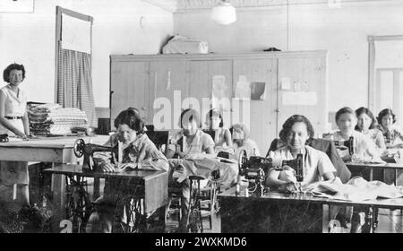 Filles dans un cours de couture dans une école indienne du Dakota du Sud CA. 1930s ou 1940s. Banque D'Images