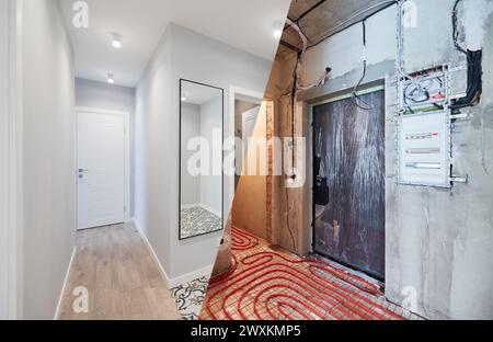 Comparaison de vieil appartement avec tuyaux de chauffage au sol et nouvel appartement rénové avec un design intérieur moderne. Salle de bain, couloir avec plancher chauffant avant et après rénovation. Banque D'Images