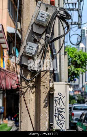 Compteurs d'électricité et câbles sur un poste de Bangkok. Banque D'Images