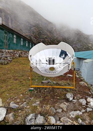 Réchauffer la théière dans une cuisinière solaire. Concept d'écologie. Énergies vertes renouvelables. Népal. Himalaya. Banque D'Images