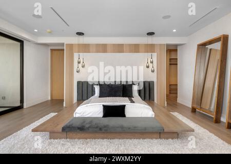 Un intérieur d'une chambre avec un lit spacieux et du parquet. Banque D'Images