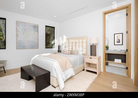 Une chambre avec un lit blanc et commode par une fenêtre. Banque D'Images