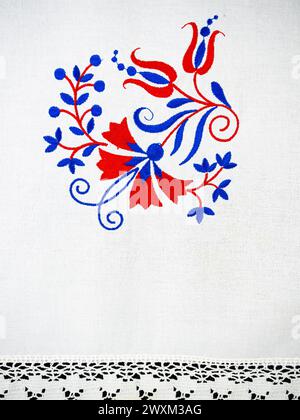 Ornement traditionnel slovène de broderie de nappe en bleu et rouge avec fleur d'oeillet Banque D'Images