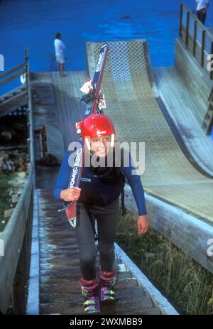 Un jeune sauteur à ski acrobatique (adolescent) monte les escaliers avant de sauter dans une piscine depuis une rampe spécialement construite au centre d'entraînement olympique de Park City, Utah - la piscine se brise Banque D'Images