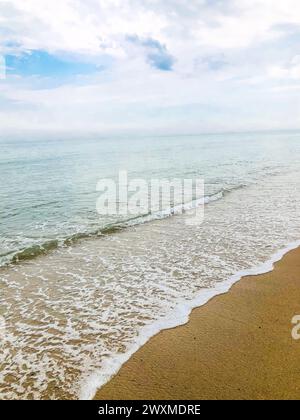 Vagues calmes roulantes sur une belle plage. Banque D'Images