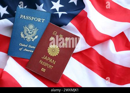 Passeport du Japon avec passeport américain sur les États-Unis d'Amérique drapeau plié en gros plan Banque D'Images