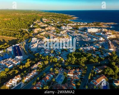 Vue aérienne drone du port, du logement et de la plage de Cala en Bosc sur l'île espagnole de Minorque. Banque D'Images