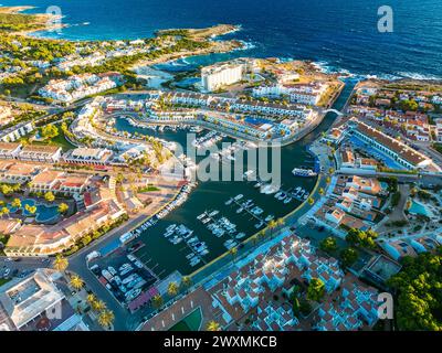 Vue aérienne drone du port, du logement et de la plage de Cala en Bosc sur l'île espagnole de Minorque. Banque D'Images