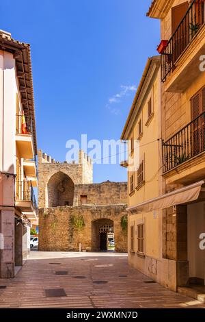 Rue dans la vieille ville d'Alcudia menant à la porte de pierre Porta del moll à Majorque, Espagne, Îles Baléares Banque D'Images