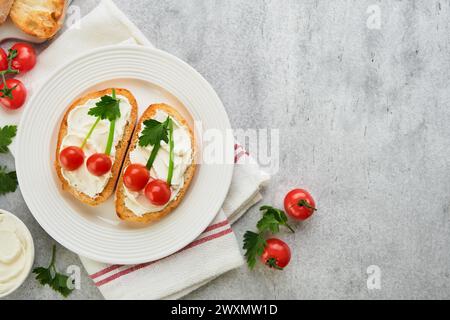 Toast drôle en forme de sandwich aux cerises mûres avec fromage à la crème, pain, tomate cerise, oignon et persil. Idée d'art alimentaire pour la nourriture des enfants. Pause créative Banque D'Images