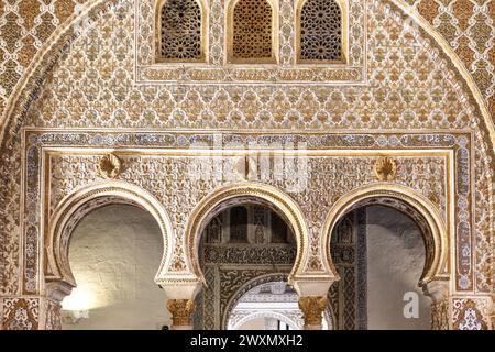 Murs ornés et arches en trou de serrure du Hall des ambassadeurs de style mudéjar à l'intérieur du Alcázar royal de Séville, Espagne Banque D'Images