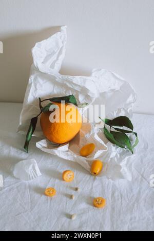 Agrumes frais juteux avec feuilles vertes sur papier blanc artisanal. Une alimentation saine. Concept minimal. Banque D'Images