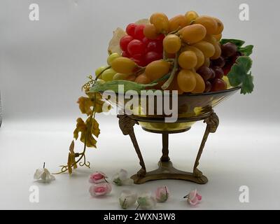 Un bol en verre avec des raisins, des tomates et des fleurs Banque D'Images