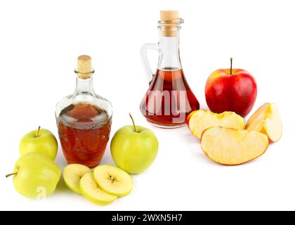 Vinaigre de pomme dans une bouteille en verre et pommes mûres isolées sur blanc. Il y a de l'espace libre pour le texte. Collage. Banque D'Images