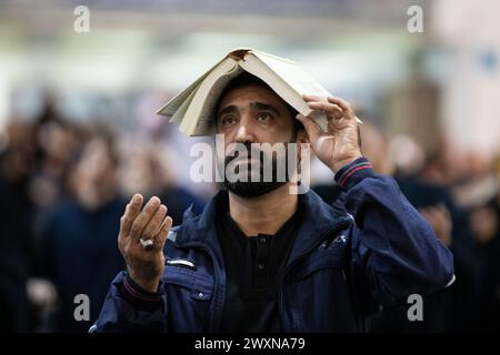 Téhéran, Téhéran, Iran. 1er avril 2024. Un adorateur chiite place des copies du Coran sur leurs têtes pendant le mois sacré islamique du Ramadan, à Téhéran, en Iran, le dimanche 1er avril, 2024. (crédit image : © Sobhan Farajvan/Pacific Press via ZUMA Press Wire) USAGE ÉDITORIAL SEULEMENT! Non destiné à UN USAGE commercial ! Banque D'Images