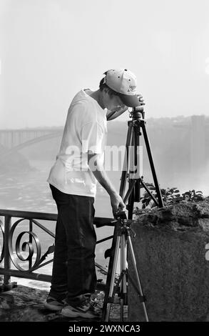 La photo montre un photographe masculin asiatique installant son trépied à Niagara Falls, au Canada. Banque D'Images
