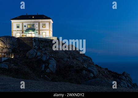 Cap Finisterre, bâtiment illuminé, ciel nocturne et océan. Une destination pour les pèlerins, était considérée comme une fin du monde. Galice, Espagne Banque D'Images