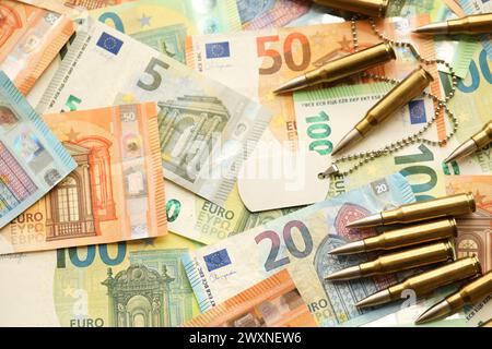 Cartouches et enveloppes jaunes sur les billets en euros. Beaucoup de billets de la monnaie de l'union européenne et des munitions en gros plan Banque D'Images