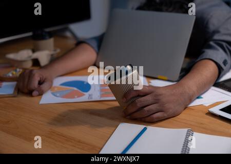 L'homme qui travaillait tard s'est endormi avec son ordinateur portable toujours au travail Banque D'Images